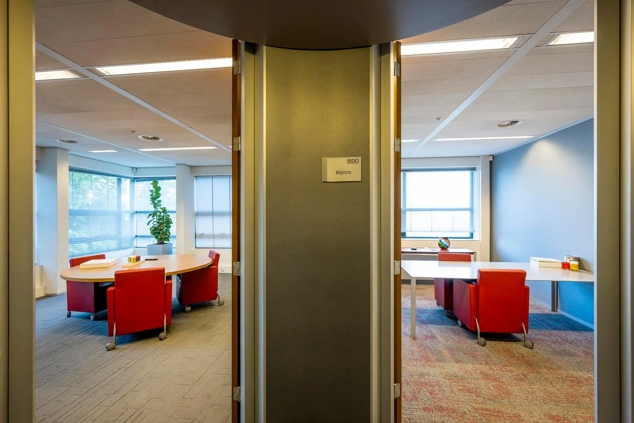 Ingang van vergaderruimtes met rode stoelen en uitzicht op kantoor aan de K.P. van der Mandelelaan, met naamplaatje ‘Blijdorp’.